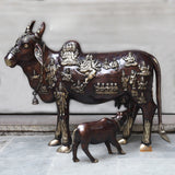 Brass Kamadhenu cow idol with calf, detailed deity relief on body and head