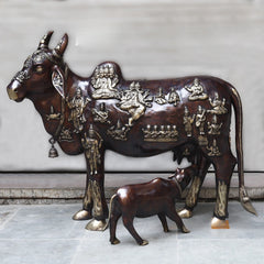 Brass Kamadhenu cow idol with calf, detailed deity relief on body and head