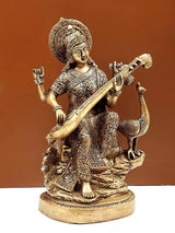 Brass Saraswati figurine seated playing veena, engraved clothing and halo