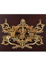 Close view of brass Lakshmi, Ganesha, Saraswati figures on ornate base in frame