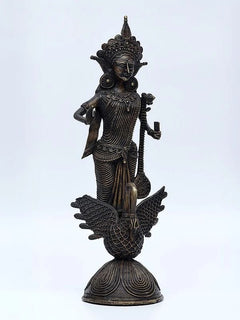 Standing Saraswati statue with ornate crown and staff, on carved swan pedestal