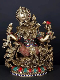 Saraswati brass statue with raised four arms, playing veena, detailed red-blue ornaments