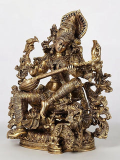 Brass Saraswati figure with four arms holding a veena, ornate detailing and crown