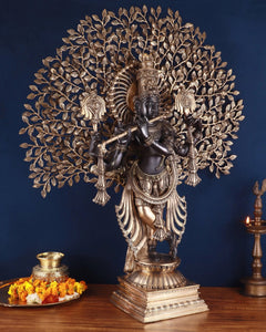 Brass Lord Krishna statue on ornate pedestal, kalpavriksha canopy with detailed leaves