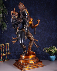Ardhanarishvara brass statue in black and gold, arms raised, on ornate round base