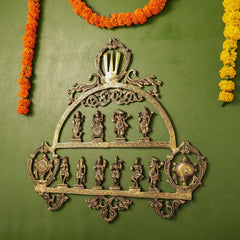 Brass Dashavatar wall decor with halo top, filigree border, and ten engraved standing avatars