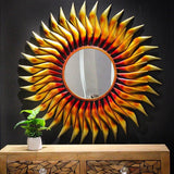 Sunburst wall mirror with round glass center and pointed iron rays, 38 in tall.