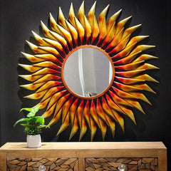 Sunburst wall mirror with round glass center and pointed iron rays, 38 in tall.