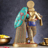Brass Radha Krishna statue from behind/side, teal shawl draped over Radha, crown visible