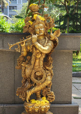 Brass Shree Krishna idol front view, flute in one hand, peacock figure, flower garland