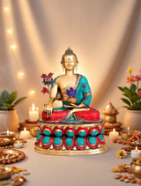 Brass medicine Buddha idol, seated, teal robe, blue lotus, red patterned cushion