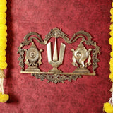 Brass wall hanging featuring shankh, chakra wheel, and Namah symbol under filigree arch