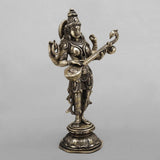 Brass Saraswati sculpture holding veena, side view of face, crown and ornaments