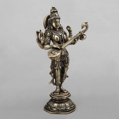 Brass Saraswati sculpture holding veena, side view of face, crown and ornaments
