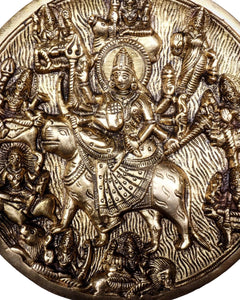 Close-up brass Durga wall medallion with crowned goddess and many devotees