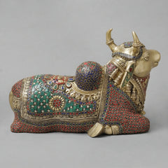 Brass Nandi sculpture, profile view with red and teal jewel-patterned body and legs