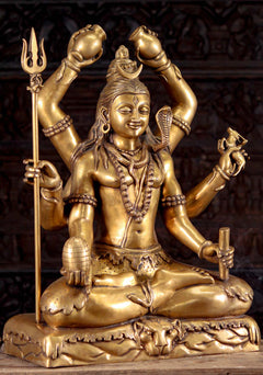 Golden six-armed Shiva idol seated, hands raised, trident in left, detailed jewelry