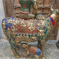 Brass holy cow with detailed carved attendants and colorful beadwork textile pattern