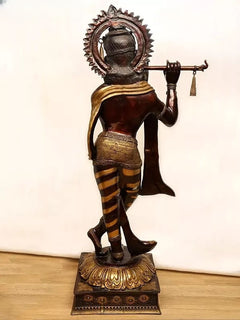 Brass Murli Krishna idol from back view, raised flute posture, gold trim and scarf