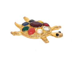 Gold-tone metal tortoise figurine with pearl white gem and dark red oval centerpiece.