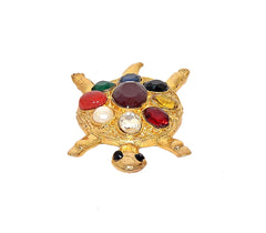 Gem-studded gold metal tortoise figurine with red, green, and black stones on top.