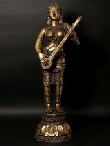 Brass standing Apsara sculpture playing a veena, tall decorative statue