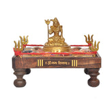 Front view: brass Shiva holding trident on decorated chowki with red border