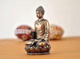 Side view: gold-tone seated Buddha resin statue with left hand resting on lap
