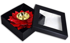 Pink lotus metal diya set in a black box, open lid revealing gold oil bowl and petals