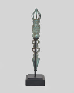 Vintage bronze phurpa ritual dagger on dark base, pointed blade with crown top