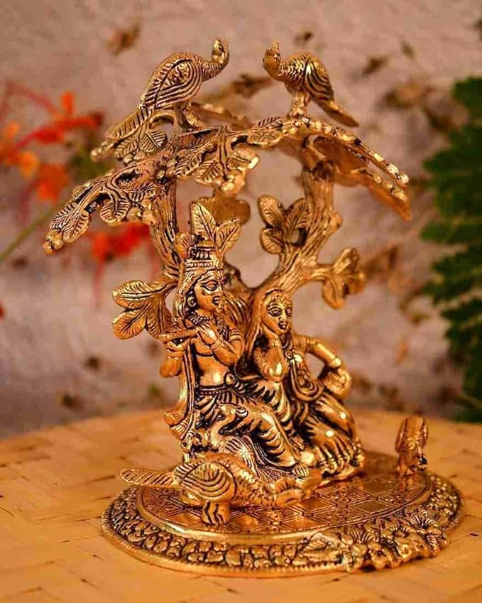 Gold-tone Radha Krishna statue seated under ornate tree with birds, detailed round base