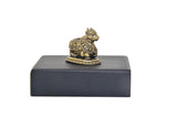Brass Nandi bull statue on dark rectangular base, rear side view