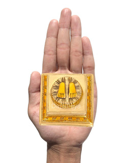 Lakshmi charan paduka brass pendant held in hand, small size