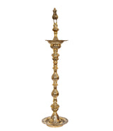 Brass oil lamp holder stand with peacock topper, stacked decorative tiers and circular base