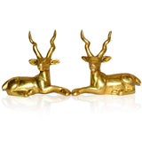 Two gold-tone sitting deer figurines with upward antlers, mirrored front views