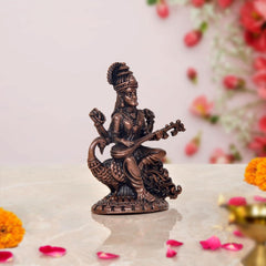 Copper Saraswati statue, rear side view showing veena and flowing engraved base