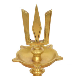 Close-up of brass diya shankh top bowl with three-pronged trident emblem