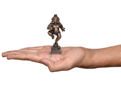Copper Bal Krishna dancing figurine, 3.5 in, held in open palm for scale