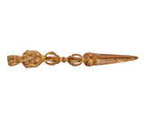 Brass-toned phurpa furba dagger pendant, pointed blade with ornate central rings