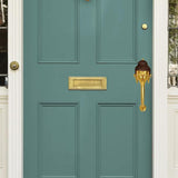 Brass Buddha-face door handle mounted on a door