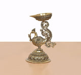 Gold-tone peacock diya lamp stand statue, bowl held above carved pedestal base