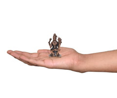 2-inch copper deity sculpture held in hand, seated pose on small pedestal