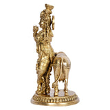 Brass Krishna statue on cow, back view with crown and jeweled ornaments