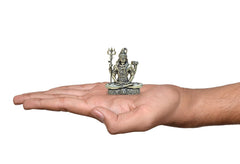 Brass Shiva deity figurine held in hand, sitting with four arms, 2 inch tall