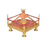 Brass Shri Yantra chowki angled view, red thread band, gold temple pillar on patterned base