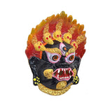 Close-up metal wall hanging showing demon eyes with evil-eye symbols, red and gold