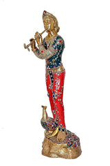 Standing Krishna idol in brass with flute, detailed blue-red outfit and peacock figurine base
