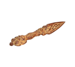 Brass phurba dagger pendant angled view, ornate grip and sharp triangular blade