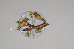 Iron birds wall decor: gold-tone birds perched on a branch, circular white backplate