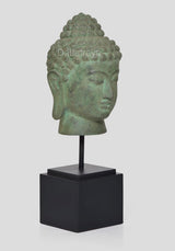 Bronze Buddha head idol on black stand, three-quarter side with detailed curls